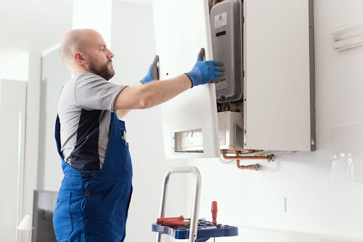 Engineer installing a new boiler to demonstrate how often should you replace your boiler and when a replacement is recommended.