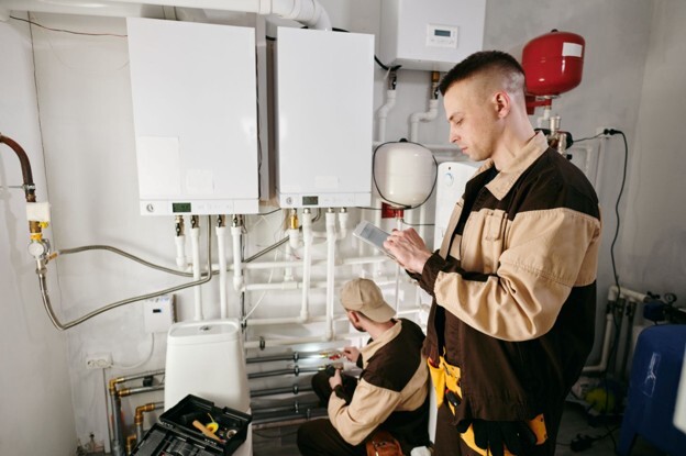 Heating engineers completing a new boiler installation and checking the heating system in a residential property.