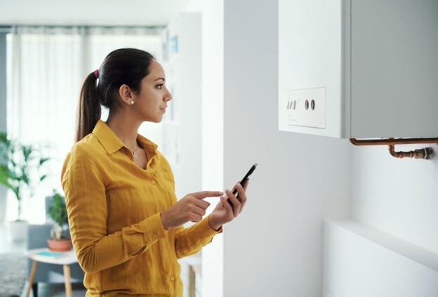 Homeowner checking a combi boiler after experiencing problems with the boiler losing pressure.