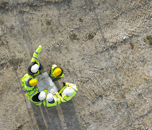 Overhead of engineers on construction site looking at design plan