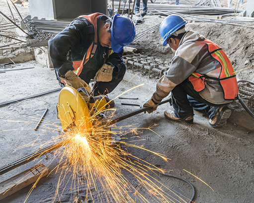 Construction site workers cutting metal