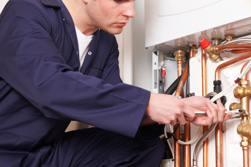 Plumber checking boiler pipes