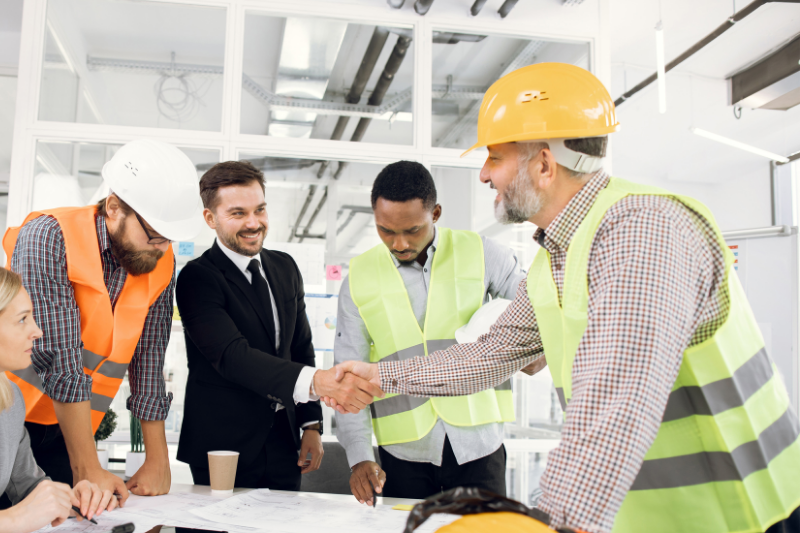 An engineer shaking hands with a client at a design meeting